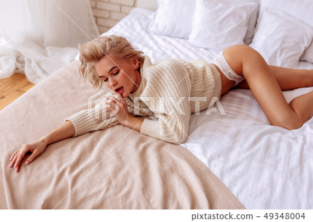 Professional photo model posing in bed for magazine cover 49348004