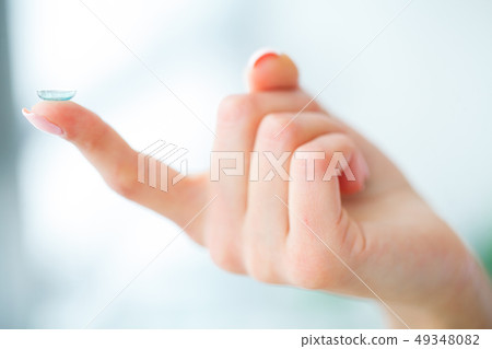 Vision Contact Lenses. Beautiful Woman Holds Finger on a Contact Lens, Closeup 49348082