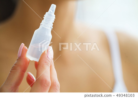 Vision And Medicine Concept. Young Girl Holds Eye Drops In Hands. Portrait of a Beautiful Woman with Vision And Medicine Concept. Young Girl Holds Eye Drops In Hands. Portrait of a Beautiful Woman with 49348103