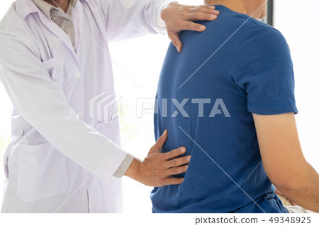 Doctor physiotherapist treating lower back pain Doctor physiotherapist treating lower back pain 49348925