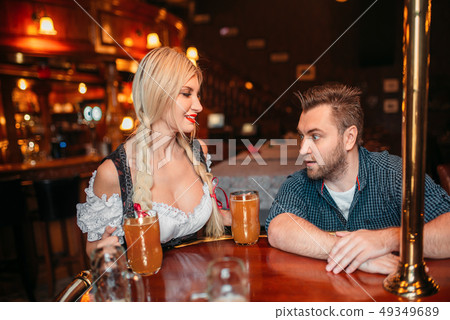Surprised drunk man stairs at breasts of waitress 49349689