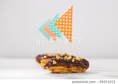 Food, desserts and bakery concept - Eclairs with chocolate decorated as a ship Food, desserts and bakery concept - Eclairs with chocolate decorated as a ship 49351815