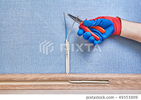 Worker cuts wires by working tool. 49353809