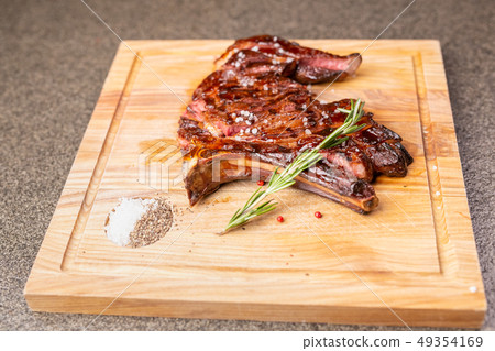 food, delicious and craft concept - cutting horse meat steak on wooden desk 49354169
