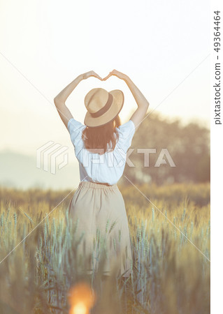 Beautiful asian woman having fun at barley field in summer at sunset time Beautiful asian woman having fun at barley field in summer at sunset time 49364464