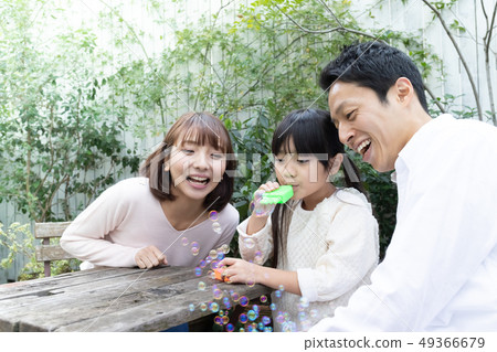 享受家庭肥皂泡的父母和孩子 享受家庭肥皂泡的父母和孩子 49366679