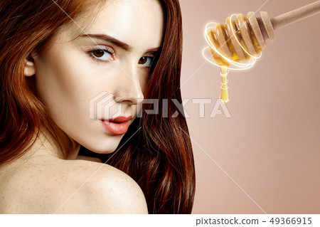 Young redhead woman and honey spoon prepare for facial mask. 49366915
