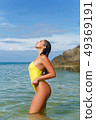 Beautiful girl posing on the beach in the hot sun 49369191