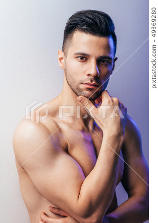 Thoughtful shirtless man portrait posing in studio 49369280