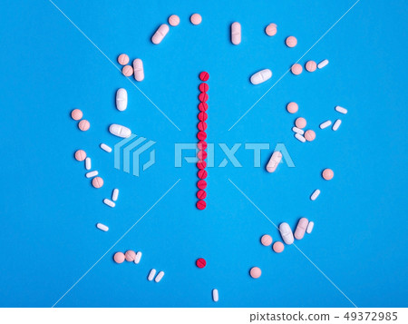 Exclamation mark from red medicine pills on blue Exclamation mark from red medicine pills on blue 49372985