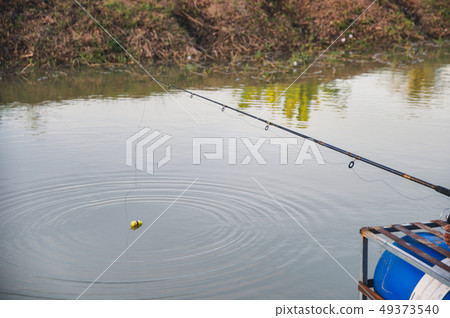 Fisherman with fishing rod and bait in swamp 49373540