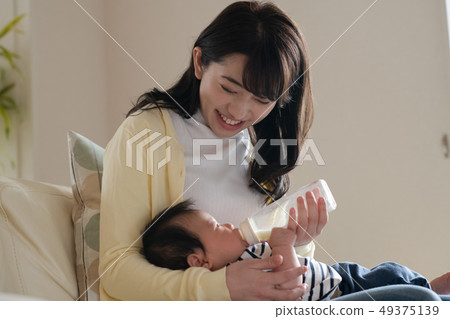 照顧做嬰孩與乳瓶的飲料牛奶 49375139