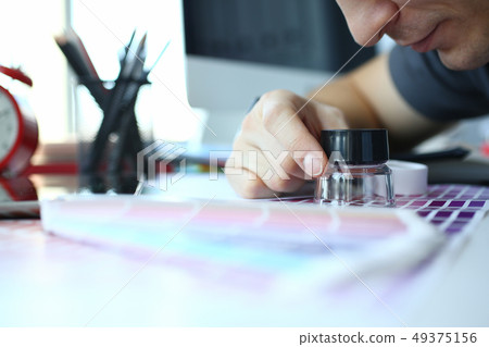 Male serviceman hold in hand magnifying glass making colour test Male serviceman hold in hand magnifying glass making colour test 49375156
