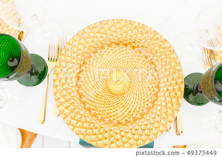 Golden dishes, green wine glasses and napkins. Catering concept. Interior of tent for wedding dinner 49375449