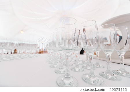 Clean glasses on white table. Catering set-up ready for the event to begin. Service area the waiter Clean glasses on white table. Catering set-up ready for the event to begin. Service area the waiter 49375533