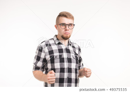 People and emotions concept - Handsome young man in plaid shirt dancing funny over white background 49375535