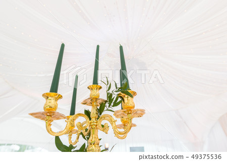 Golden chandelier with green candles. Catering concept. Interior of tent for wedding dinner, ready 49375536