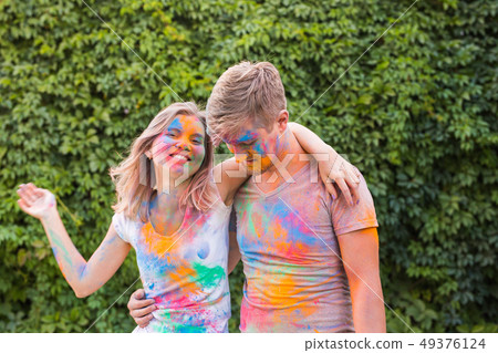 Friendship, festival of holi, people concept - young couple playing with colors at the festival of 49376124
