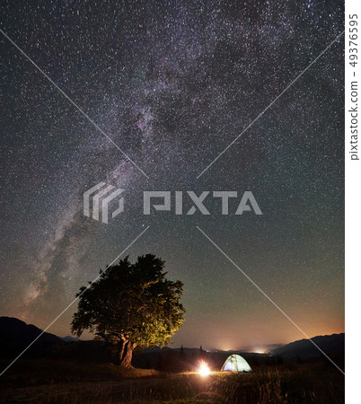 Tourist camping at night in the mountains under starry sky Tourist camping at night in the mountains under starry sky 49376595