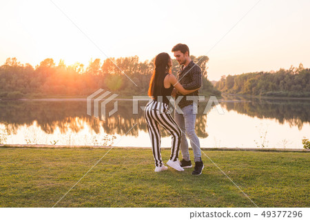 Romantic, social dance and people concept - young couple dancing bachata on the background of sunset Romantic, social dance and people concept - young couple dancing bachata on the background of sunset 49377296