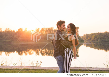Romantic, social dance and people concept - young couple dancing a tango or bachata near the lake Romantic, social dance and people concept - young couple dancing a tango or bachata near the lake 49377315