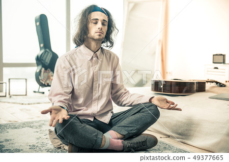 Tranquil good-looking young guy having meditative period 49377665