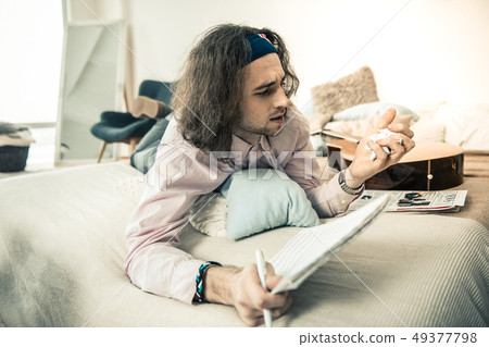 Unsatisfied long-haired guy compressing page from his personal album 49377798