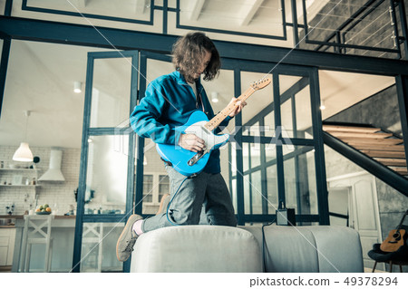 Reckless dark-haired musician expressing his feelings while playing 49378294