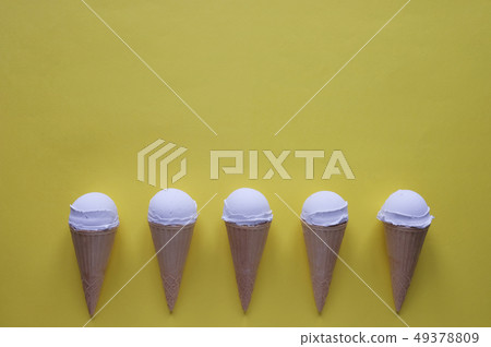 Row of vanilla ice cream cones on yellow Row of vanilla ice cream cones on yellow 49378809
