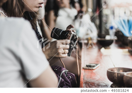 Young woman prepares a camera Young woman prepares a camera 49381824