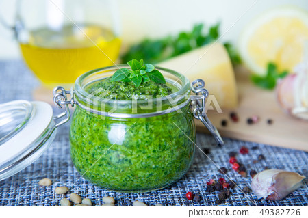 Homemade basil sauce pesto in a glass jar. Homemade basil sauce pesto in a glass jar. 49382726
