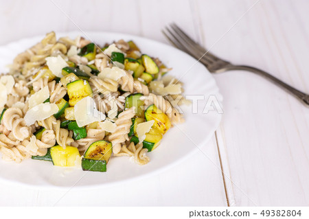 Fusilli pasta with zucchini on grey wood Fusilli pasta with zucchini on grey wood 49382804
