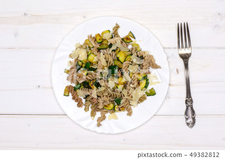 Fusilli pasta with zucchini on grey wood Fusilli pasta with zucchini on grey wood 49382812