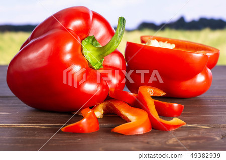 Fresh red paprika with field behind Fresh red paprika with field behind 49382939