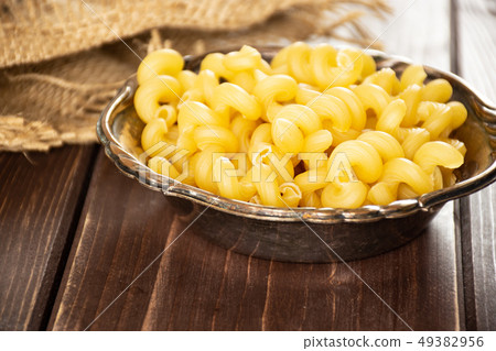 Cavatappi pasta raw on brown wood Cavatappi pasta raw on brown wood 49382956