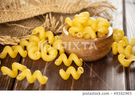 Cavatappi pasta raw on brown wood Cavatappi pasta raw on brown wood 49382965