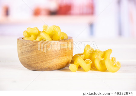 Cavatappi pasta raw with kitchen behind 49382974