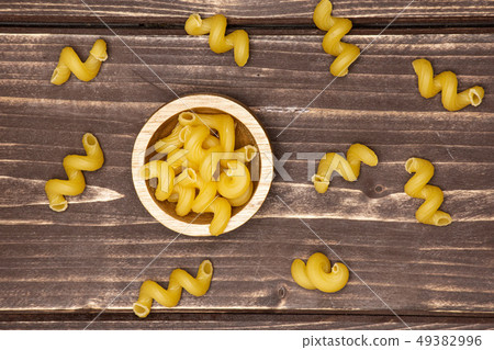 Cavatappi pasta raw on brown wood Cavatappi pasta raw on brown wood 49382996
