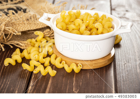 Cavatappi pasta raw on brown wood Cavatappi pasta raw on brown wood 49383003