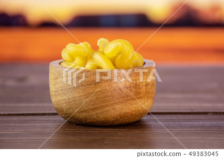 Cavatappi pasta raw with autumn field behind Cavatappi pasta raw with autumn field behind 49383045