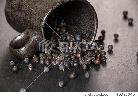 Dry juniper berries on grey stone Dry juniper berries on grey stone 49383049