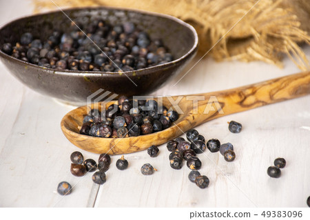 Dry juniper berries on grey wood 49383096