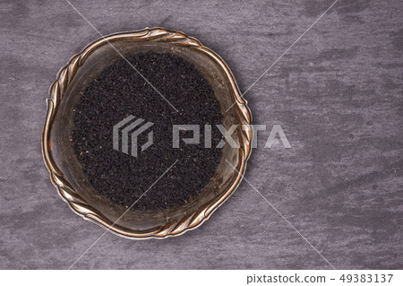 Black cumin seeds on grey stone 49383137