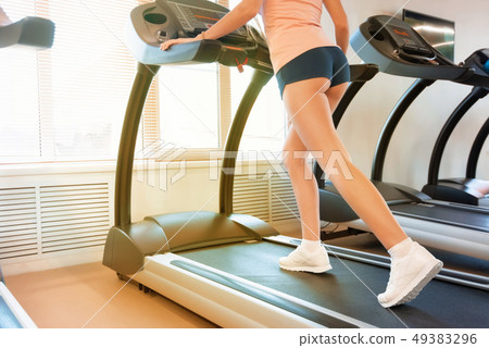 Close up young fit woman on modern treadmill in gym. Lower part view 49383296