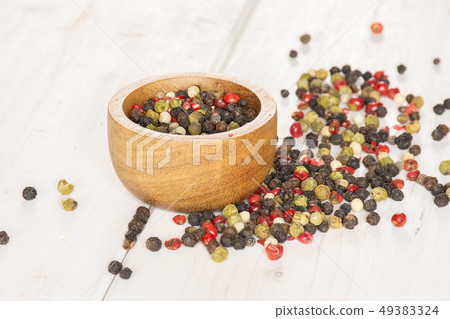 Four colors of peppercorns on grey wood Four colors of peppercorns on grey wood 49383324