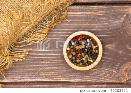 Four colors of peppercorns on brown wood Four colors of peppercorns on brown wood 49383331