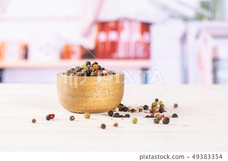 Four colors of peppercorns with kitchen behind 49383354
