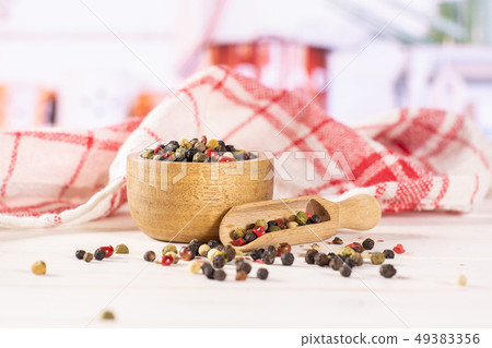 Four colors of peppercorns with kitchen behind Four colors of peppercorns with kitchen behind 49383356