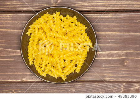 Raw italian torti pasta on brown wood Raw italian torti pasta on brown wood 49383390