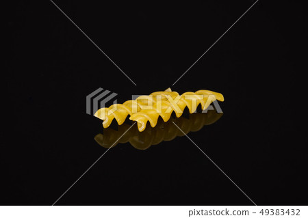 Raw italian torti pasta isolated on black glass Raw italian torti pasta isolated on black glass 49383432